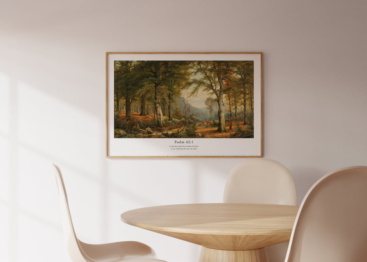 Framed landscape print on a wall above a round wooden table with chairs.