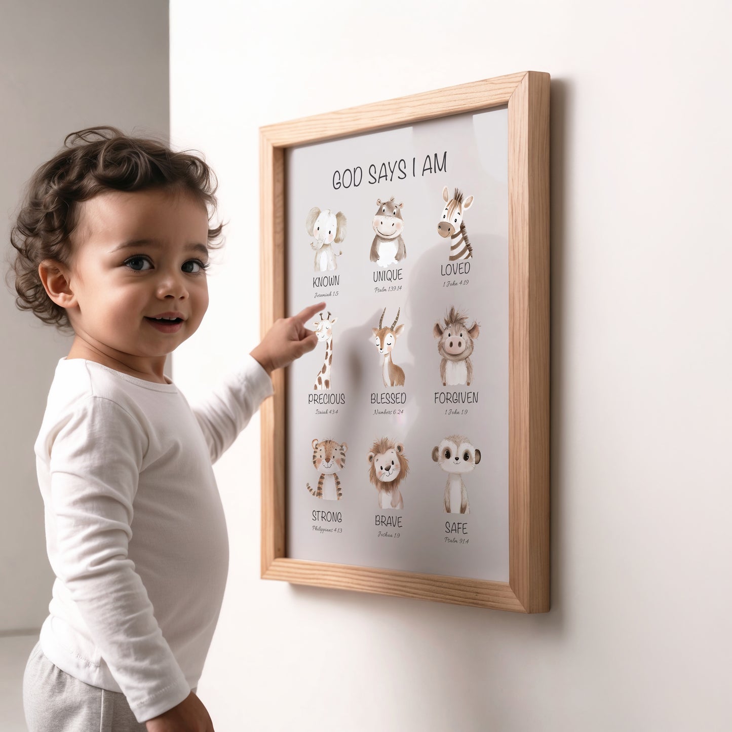 Child pointing at a framed Christian nursery poster with animal illustrations and bible affimations on a wall.