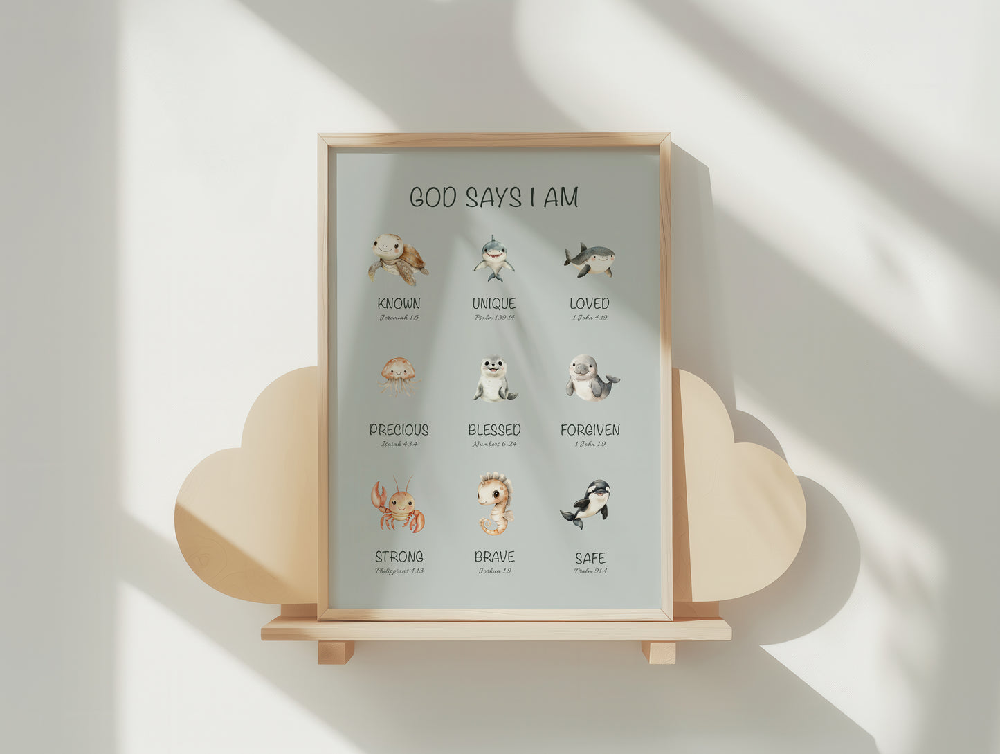 Framed children's christian print with ocean animal illustrations and affirmation bible verses on a wooden stand against a light background