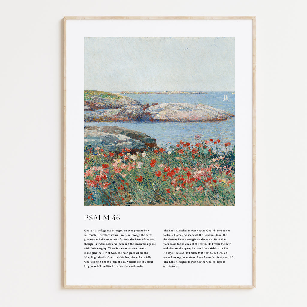 A framed wall art print featuring a landscape painting with blue water, gray rocks, and red flowers, plus printed text below reading 'PSALM 46'. The frame is light wood and shown against a plain light background.