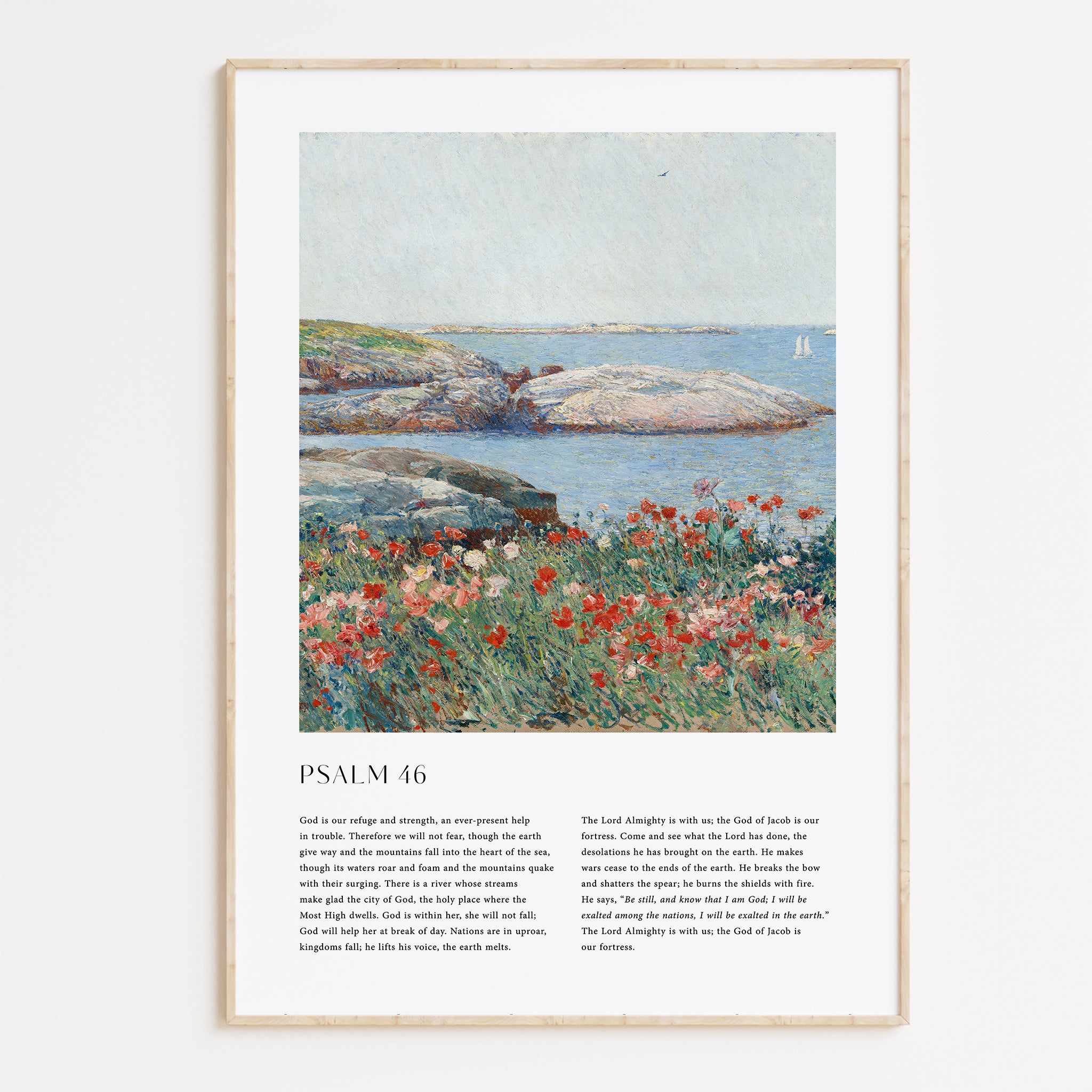 A framed wall art print featuring a landscape painting with blue water, gray rocks, and red flowers, plus printed text below reading 'PSALM 46'. The frame is light wood and shown against a plain light background.