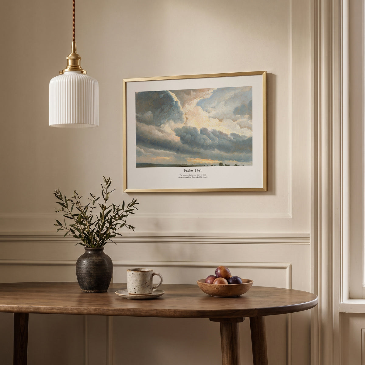Framed scripture wall art with Psalm 19:1 and a luminous cloudy sky, displayed above a dining table in a neutral interior.