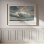Psalm 19:1 Christian wall art featuring dramatic clouds and a luminous sky, framed in natural wood on a white panelled wall.
