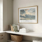 Framed Psalm 19:1 scripture wall art with a blue-grey cloudscape, displayed in a bright neutral utility room.