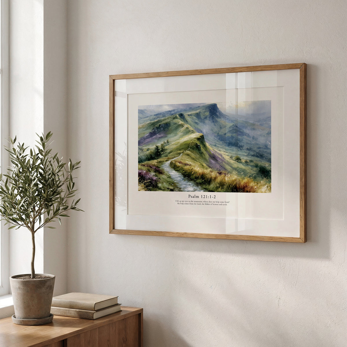 Christian wall art featuring Psalm 121:1–2 and a misty mountain landscape, framed beside soft natural greenery.