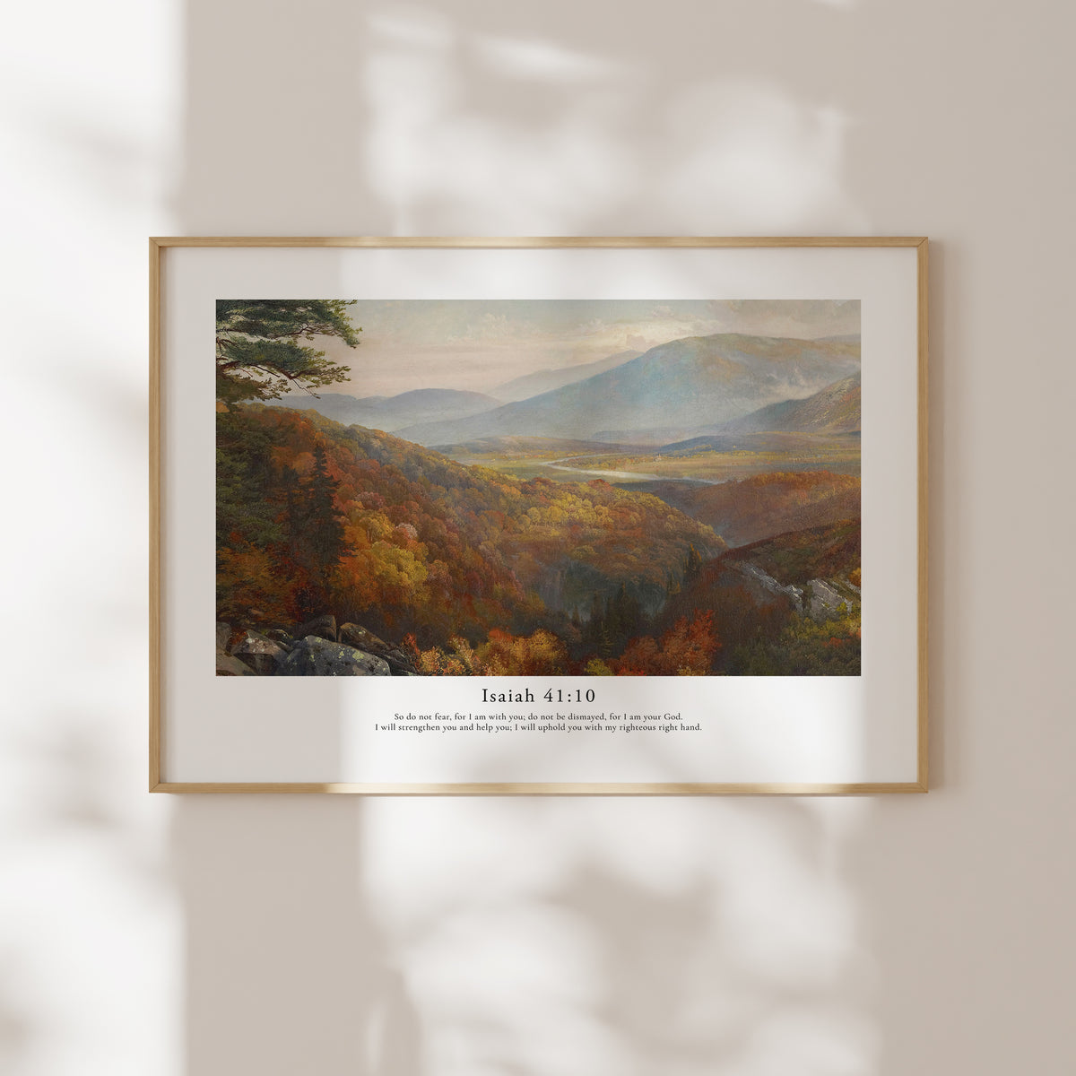 Framed Isaiah 41:10 Bible verse wall art with a warm mountain landscape and soft natural window shadows.