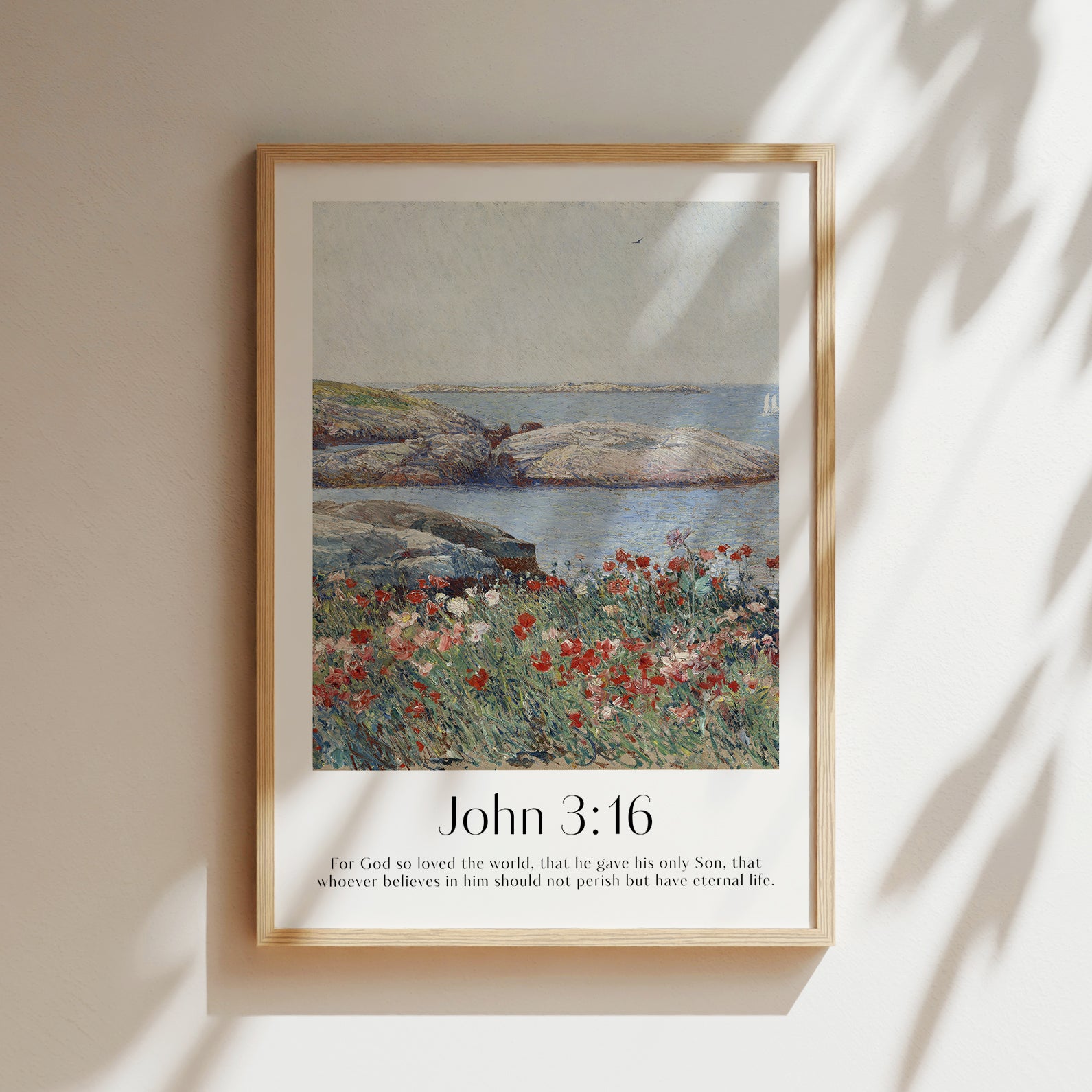 A framed Christian Print hanging in a room with a vintage seascape and the bible verse John 3:16