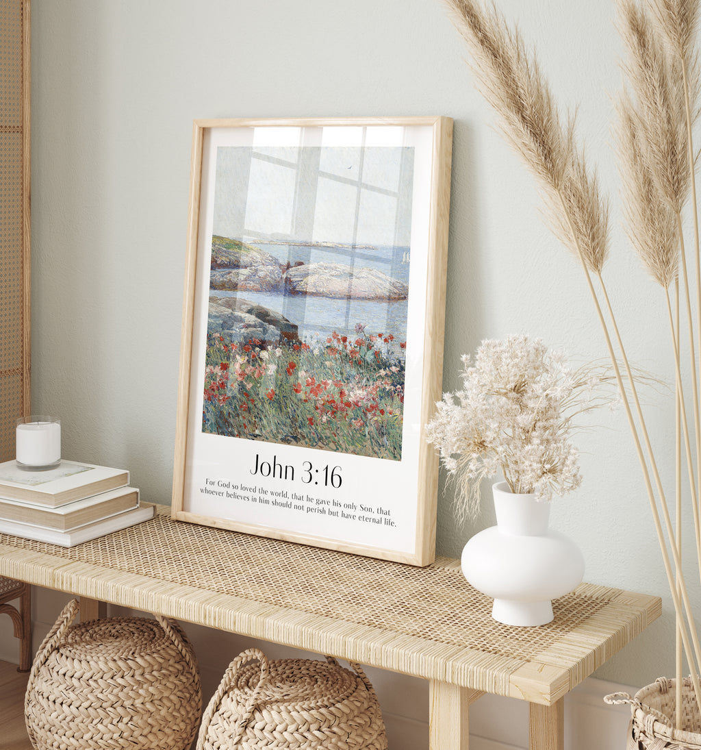 A framed Christian Print on a cabinet with a vintage seascape and the bible verse John 3:16