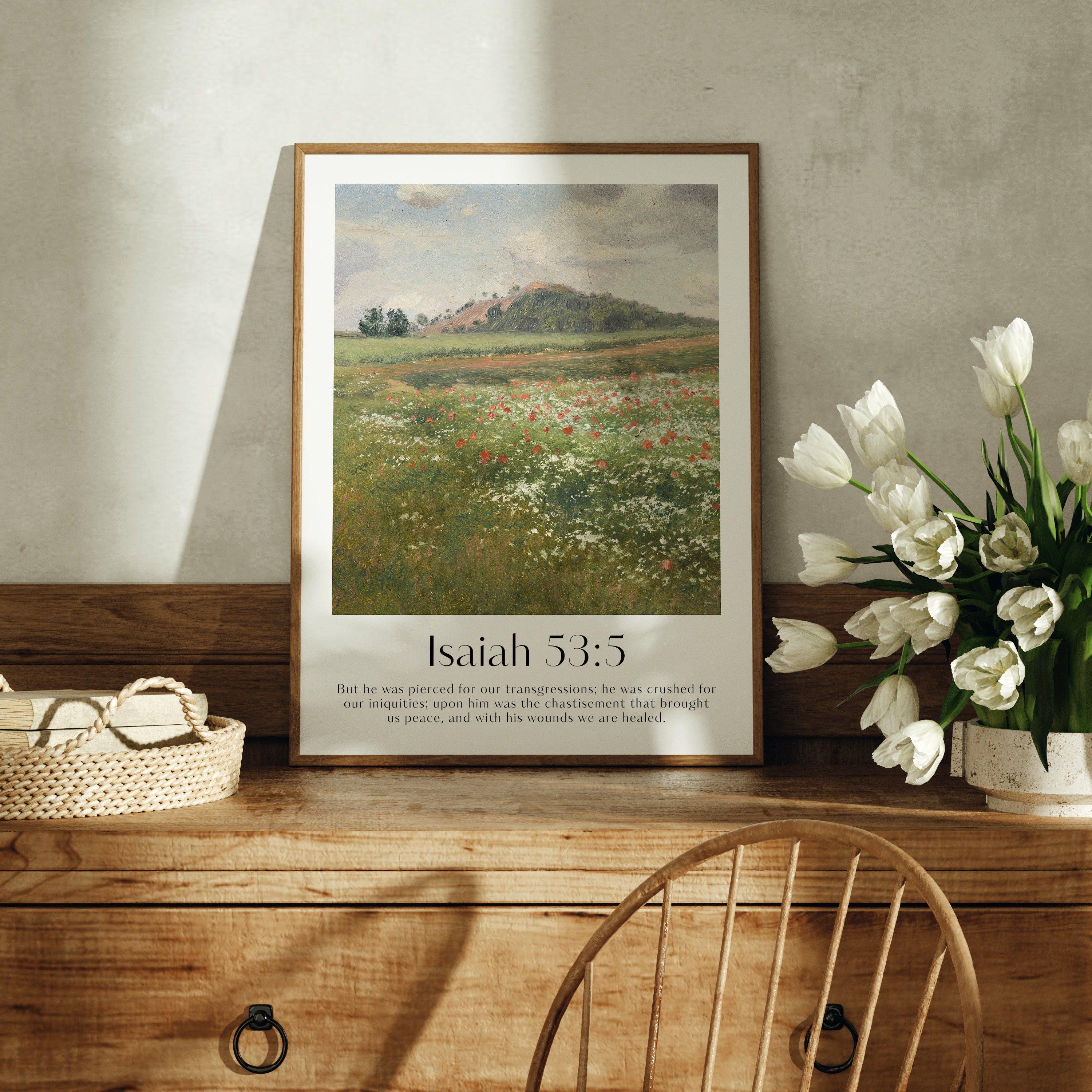 A framed Christian Print on a cabinet with a vintage landscape and the bible verse Isaiah 53:5