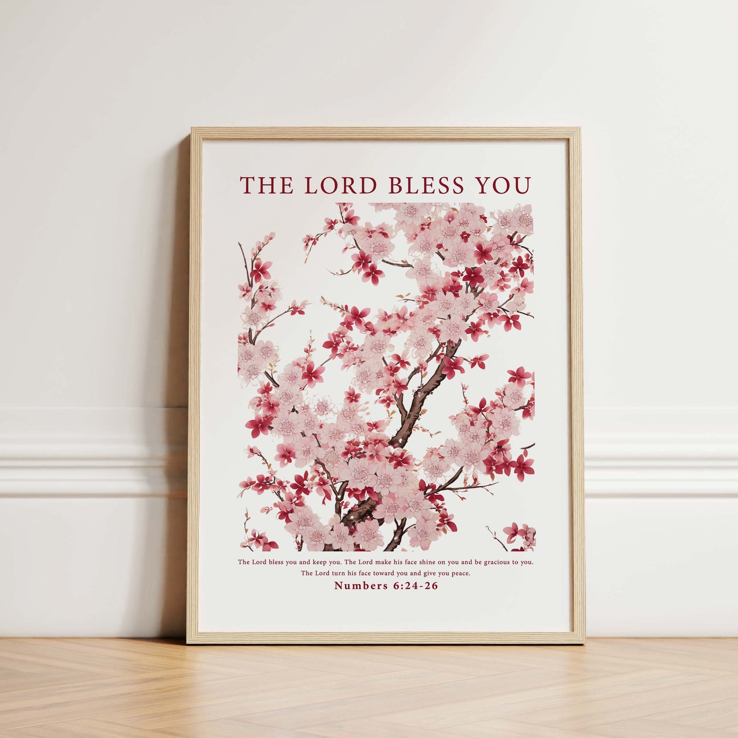 Framed Christian wall art print featuring a delicate cherry blossom tree with light pink and deep red flowers. The artwork is paired with the Bible verse Numbers 6:24-26: "The Lord bless you and keep you; the Lord make his face shine on you and be gracious to you; the Lord turn his face toward you and give you peace." This floral design combines natural beauty with spiritual blessing, perfect for any home or peaceful space.