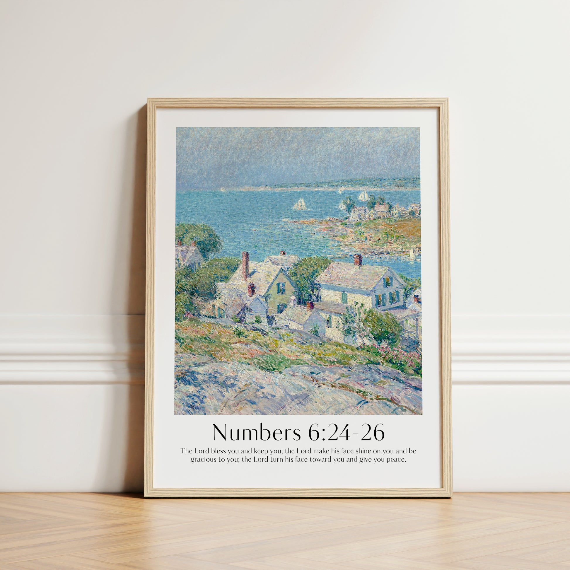 Framed Christian wall art print featuring a serene coastal village scene inspired by Childe Hassam. Displays the Bible verse Numbers 6:24-26: "The Lord bless you and keep you; the Lord make his face shine on you and be gracious to you; the Lord turn his face toward you and give you peace." This artwork blends impressionist-style scenery with a comforting scripture, making it a peaceful addition to any Christian home. Elegantly framed in light wood, perfect for enhancing living room or bedroom decor.