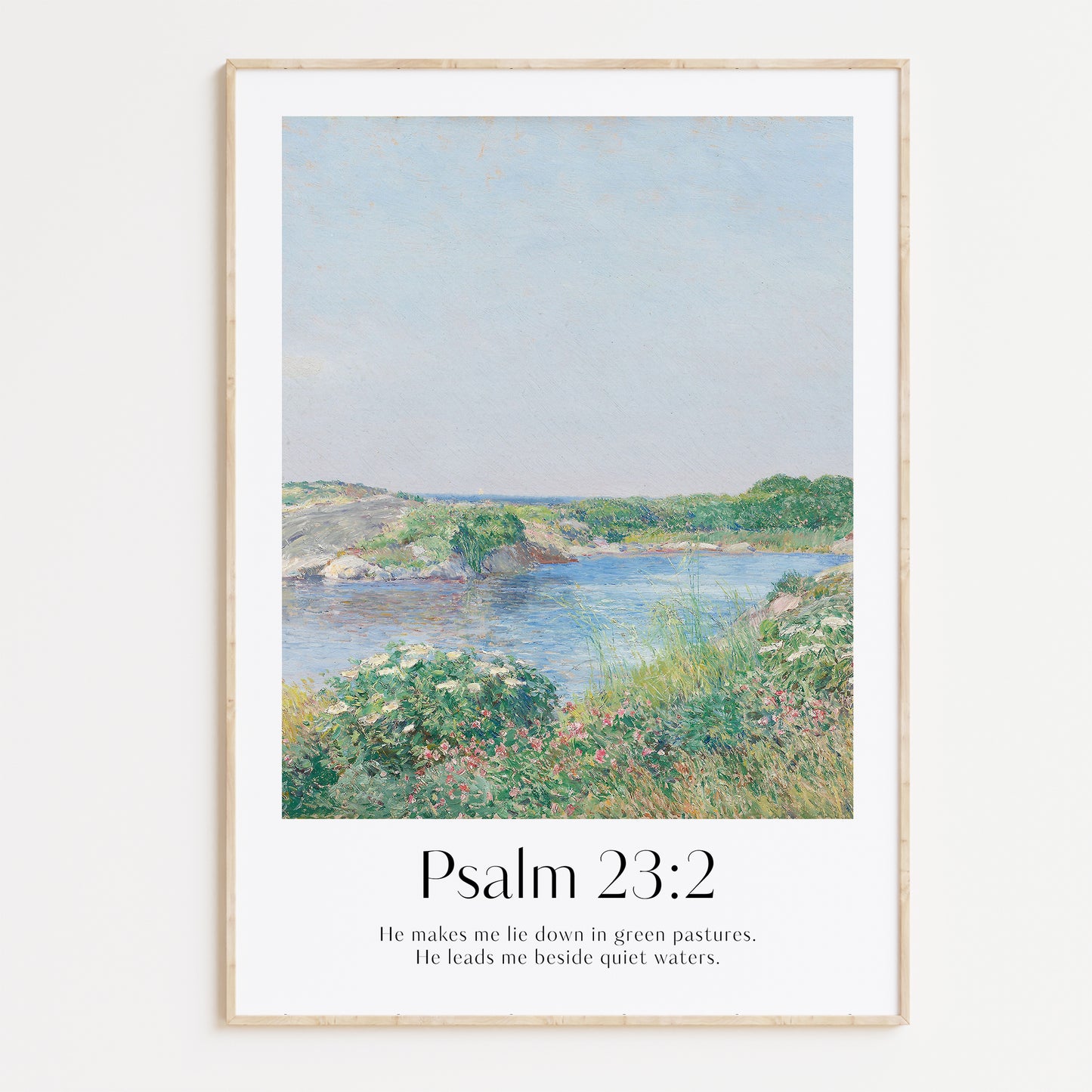 Framed Christian wall art print featuring a serene landscape inspired by Childe Hassam. Displays the Bible verse Psalm 23:2: "He makes me lie down in green pastures. He leads me beside quiet waters." This artwork combines a peaceful, impressionist-style landscape with comforting scripture, making it a tranquil addition to any Christian home. Elegantly framed in light wood, ideal for enhancing living room or bedroom decor.