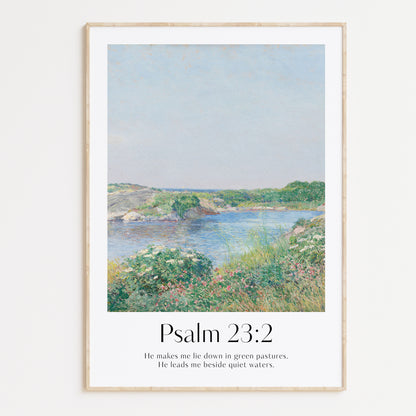 Framed Christian wall art print featuring a serene landscape inspired by Childe Hassam. Displays the Bible verse Psalm 23:2: "He makes me lie down in green pastures. He leads me beside quiet waters." This artwork combines a peaceful, impressionist-style landscape with comforting scripture, making it a tranquil addition to any Christian home. Elegantly framed in light wood, ideal for enhancing living room or bedroom decor.