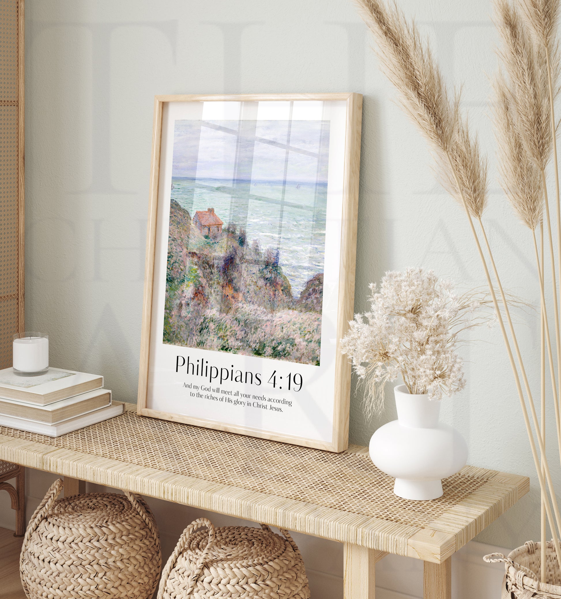 Framed Christian wall art print inspired by Claude Monet, depicting a serene coastal scene with a small cottage nestled between hills. The artwork is paired with the Bible verse Philippians 4:19: "And my God will meet all your needs according to the riches of His glory in Christ Jesus." This artwork beautifully combines the tranquility of nature with spiritual encouragement, perfect for any home.