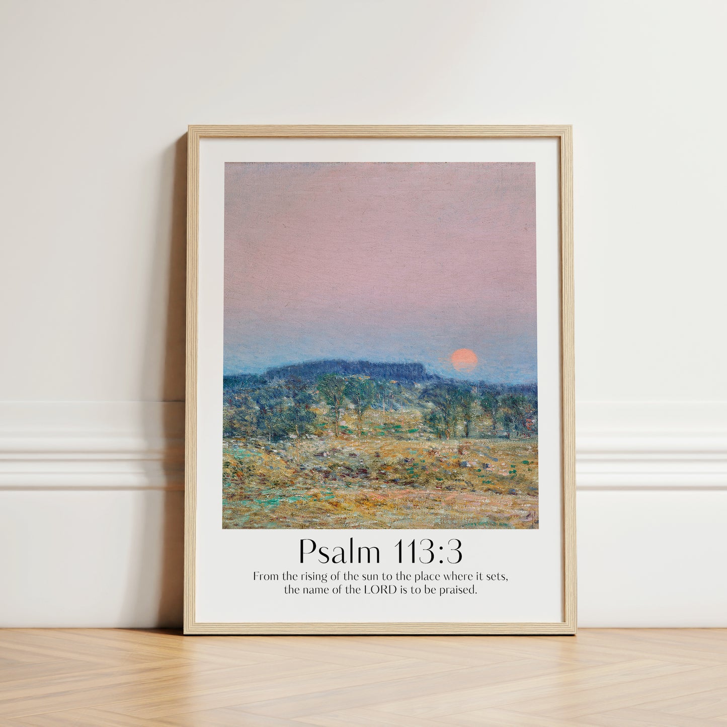 Framed Christian wall art print featuring a serene sunrise landscape inspired by Childe Hassam. Displays the Bible verse Psalm 113:3: "From the rising of the sun to the place where it sets, the name of the LORD is to be praised." This artwork combines impressionist-style scenery with uplifting scripture, making it a peaceful addition to any Christian home. Elegantly framed in light wood, perfect for enhancing living room or bedroom decor.