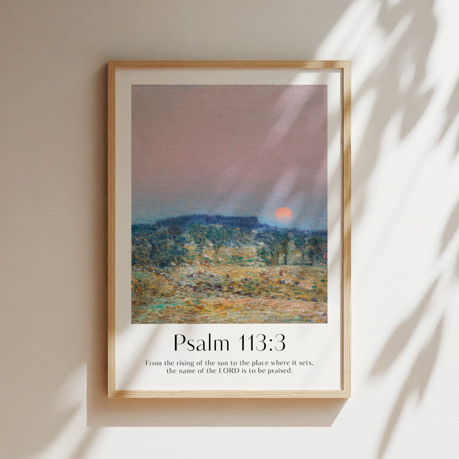 Framed Christian wall art print featuring a serene sunrise landscape inspired by Childe Hassam. Displays the Bible verse Psalm 113:3: "From the rising of the sun to the place where it sets, the name of the LORD is to be praised." This artwork combines impressionist-style scenery with uplifting scripture, making it a peaceful addition to any Christian home. Elegantly framed in light wood, perfect for enhancing living room or bedroom decor.