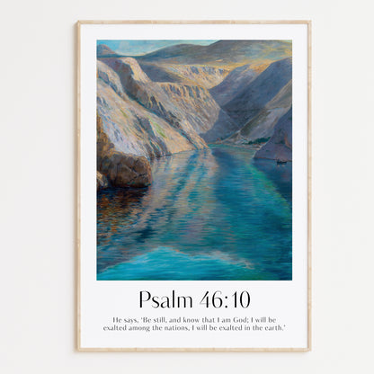 Framed Christian wall art print featuring a serene landscape inspired by Menci Clement. The artwork displays a tranquil river flowing between majestic mountains, paired with the Bible verse Psalm 46:10: "He says, ‘Be still, and know that I am God; I will be exalted among the nations, I will be exalted in the earth.’" This piece combines peaceful scenery with spiritual reflection, making it an ideal addition to any home or prayer space.