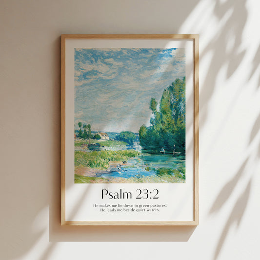 Framed Christian wall art print featuring a vintage-style countryside river scene inspired by Alfred Sisley. The artwork is paired with the Bible verse Psalm 23:2: "He makes me lie down in green pastures. He leads me beside quiet waters." This peaceful imagery, combined with the comforting scripture, creates a serene addition to any home or prayer space.