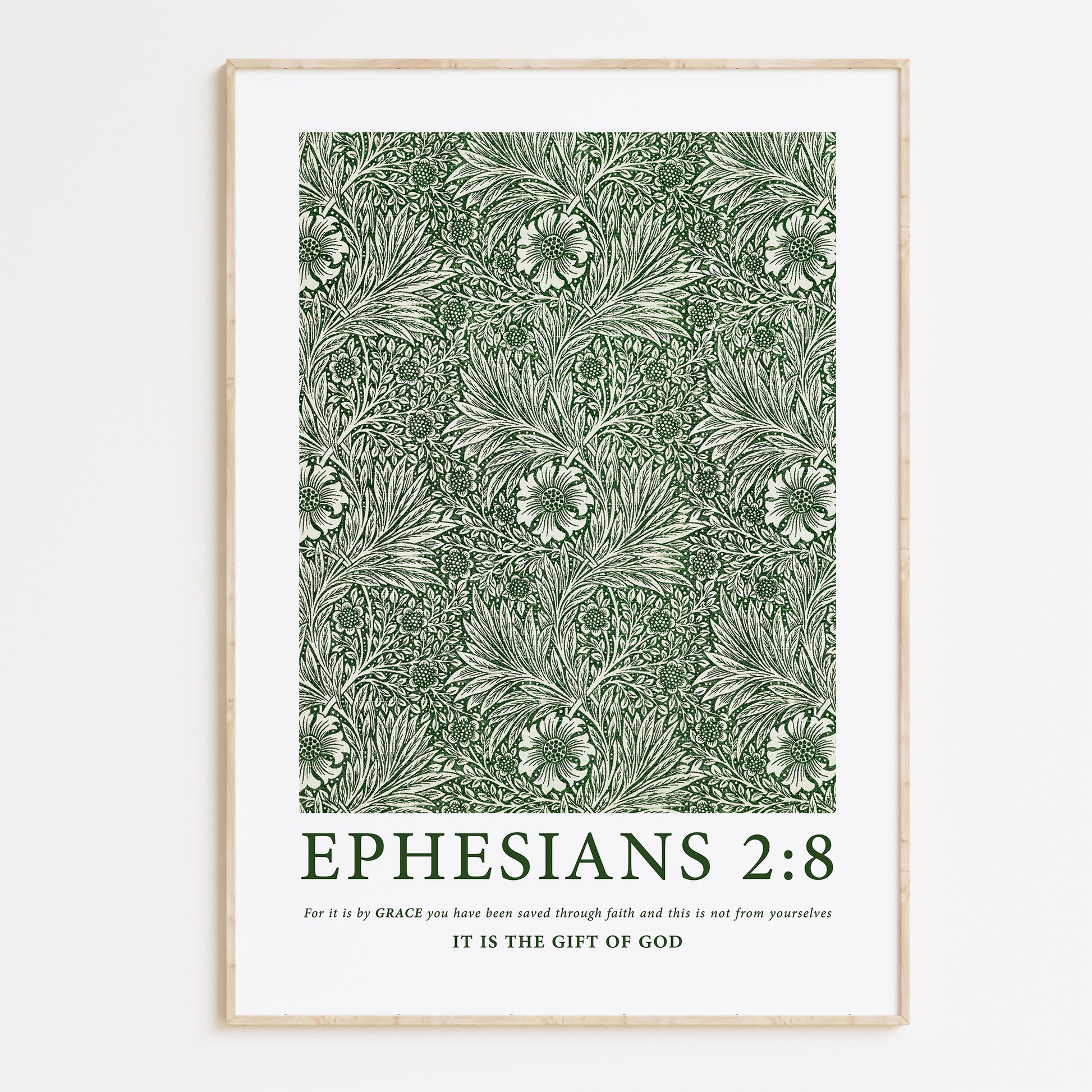 Framed Christian wall art print featuring a green botanical pattern by William Morris. Displays the Bible verse Ephesians 2:8: "For it is by grace you have been saved through faith and this is not from yourselves, it is the gift of God." This artwork blends classic, nature-inspired design with powerful scripture, making it a meaningful addition to any Christian home. Elegantly framed in light wood, ideal for enhancing living room or prayer space decor.